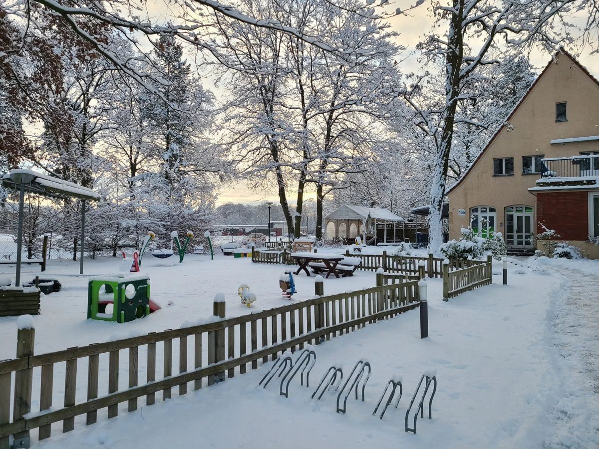 Der verschneite Spielplatz mit Schaukeln und Klettergeräten im Winter