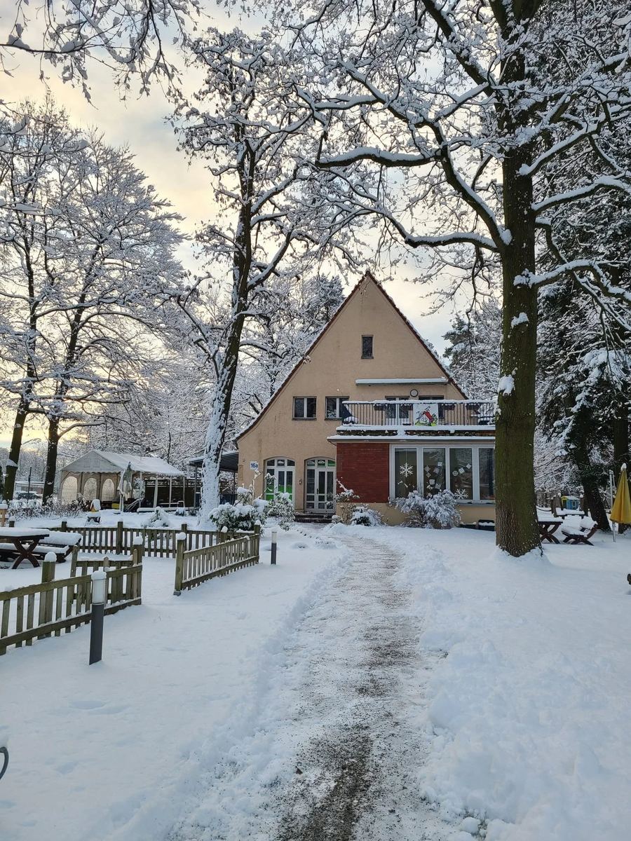 Das Kitagebäude im Schnee mit geräumtem Weg zum Eingang